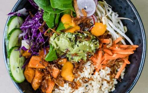 Grain bowl with rice, purple cabbage, carrot, cucumber and mango