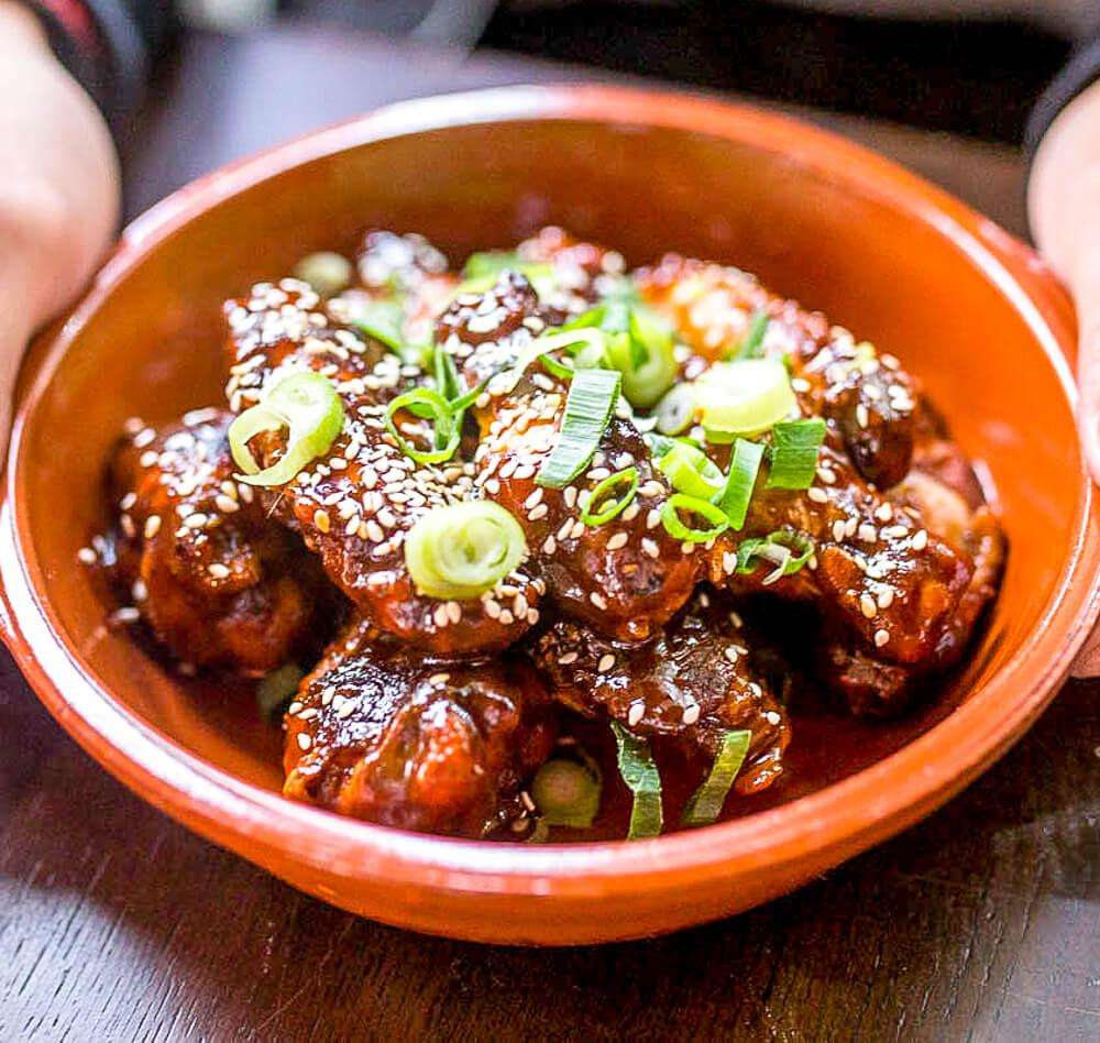 Slow-smoked chicken wings glazed with sesame and spring onion