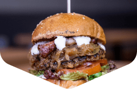 Loaded burger with a beef pattie, melted cheese and tomato