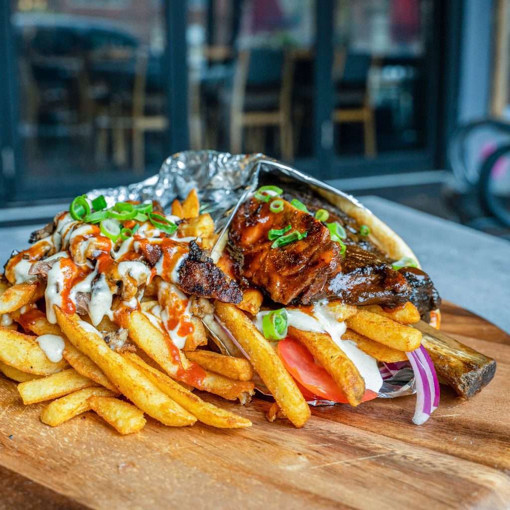 Ribovlaki rib wrap unwrapped in foil beside loaded fries