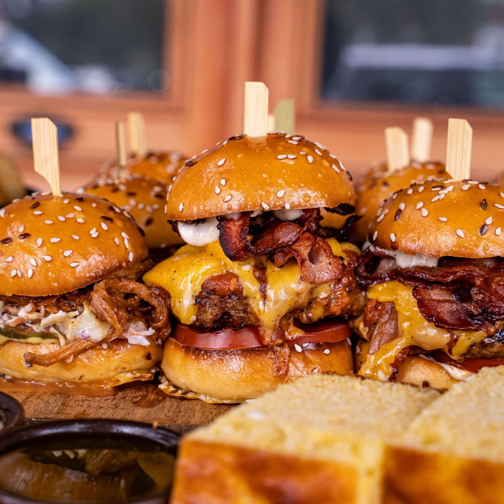 Loaded burger sliders with bacon and cheese on a board