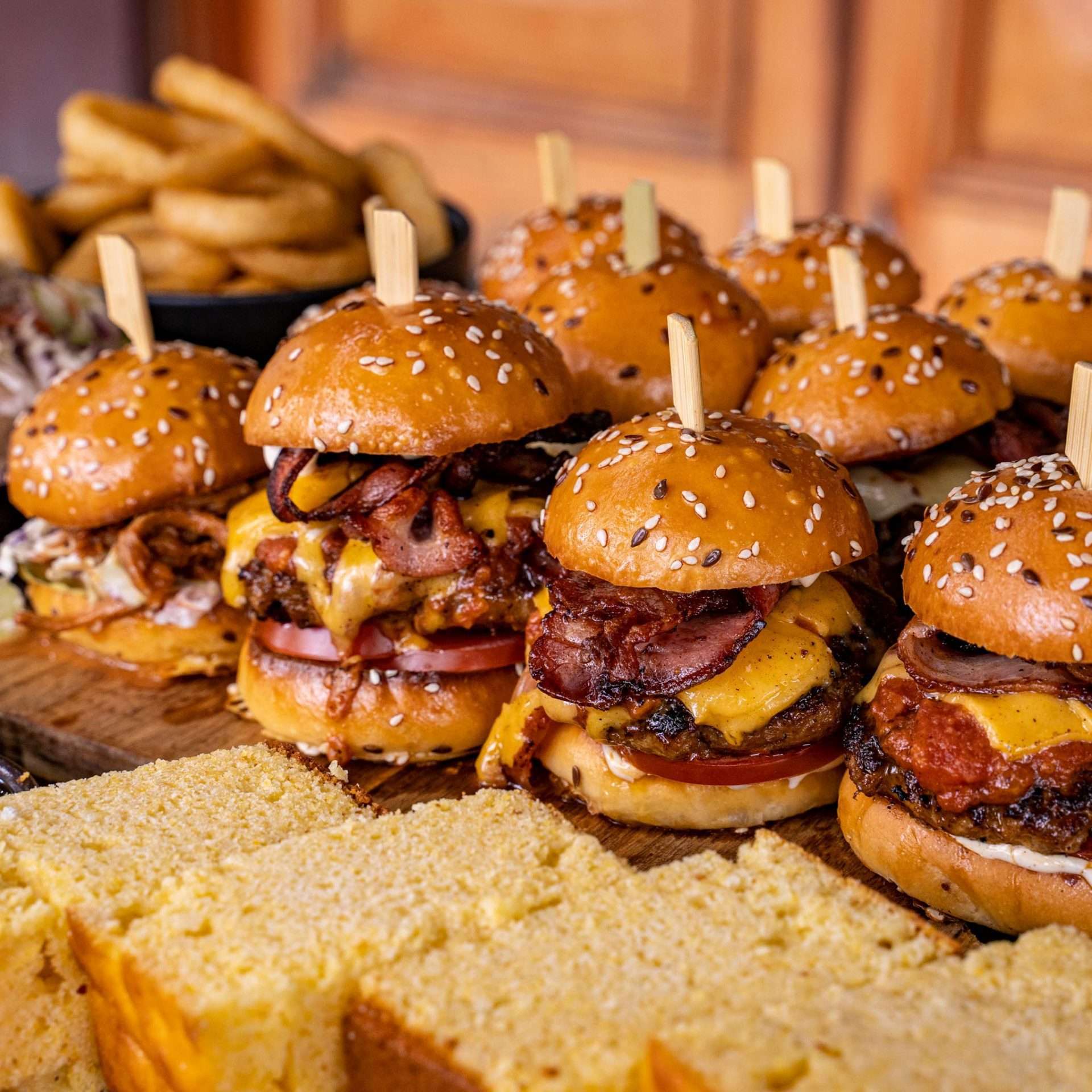 Platter of mini burger sliders with chips and cornbread for catering