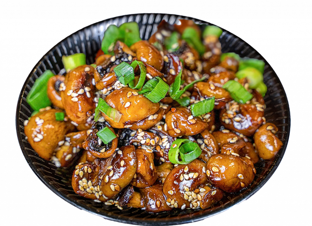 Bowl of sticky glazed mushrooms with sesame and spring onion