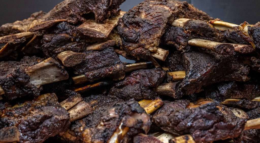 Stack of smoked beef ribs piled on a board