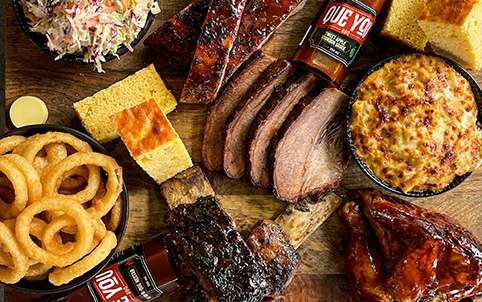 Overhead spread of brisket, ribs, onion rings and cornbread