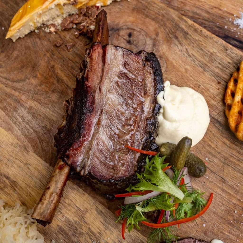 Wagyu Beef Rib on a board with mash, coleslaw and pickle