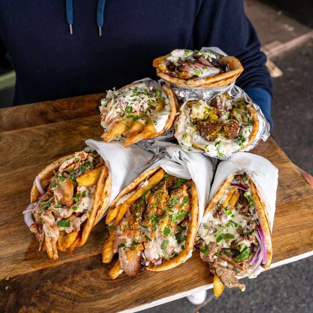 Board stacked with wrapped Skordo souvlaki wraps