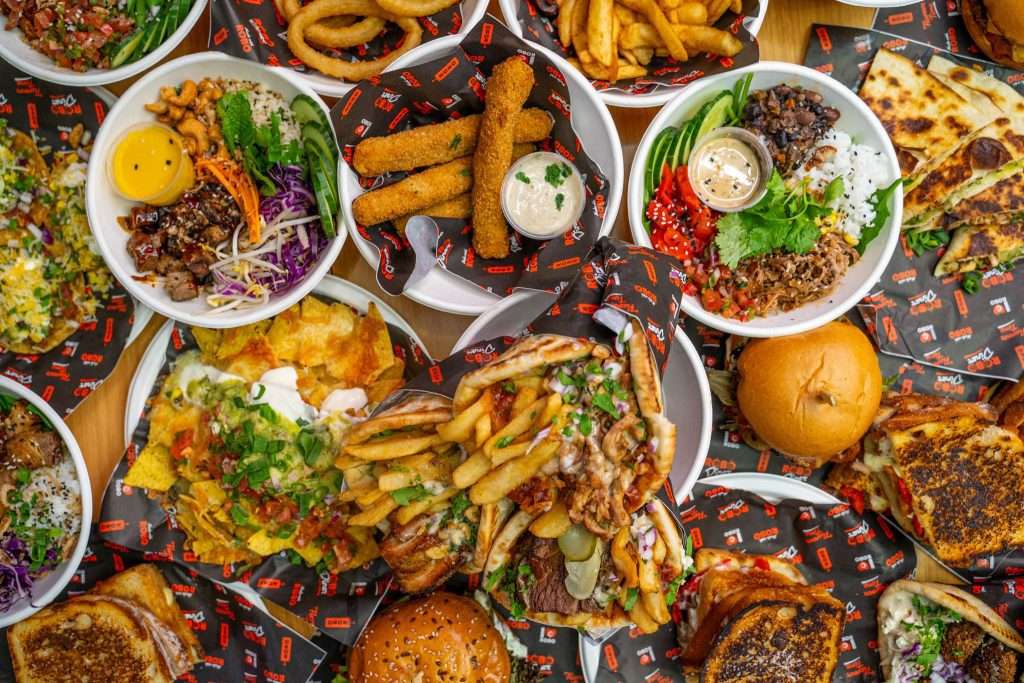 Overhead spread of Robo Diner dishes including bowls, wraps and fries