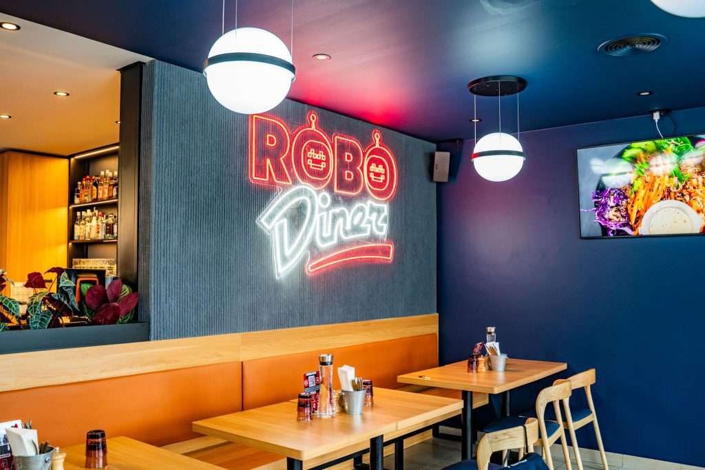 Robo Diner restaurant interior with neon sign and booth seating