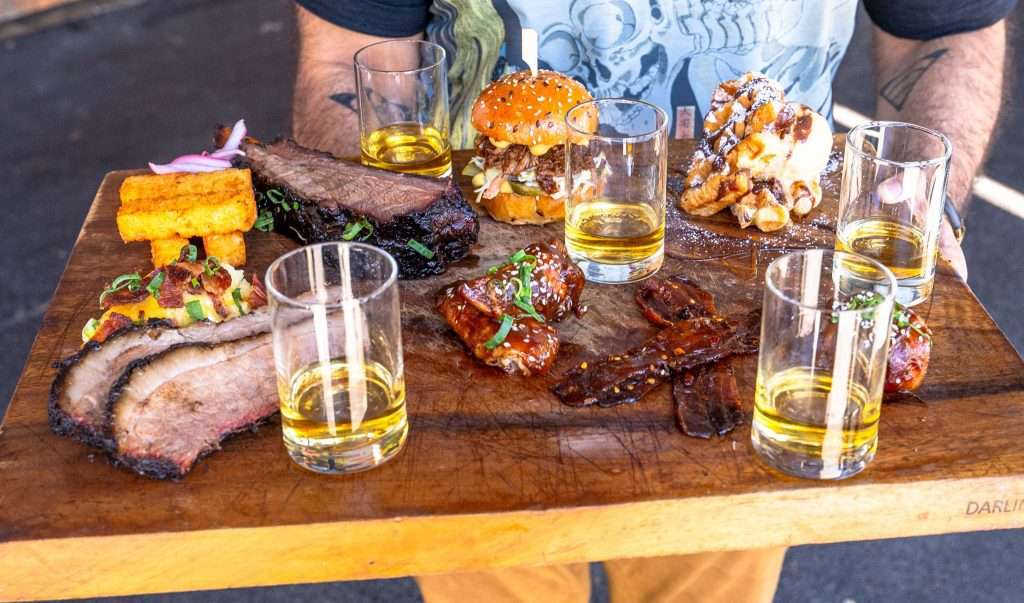 BBQ and Bourbon Degustation board with ribs, wings and bourbon glasses