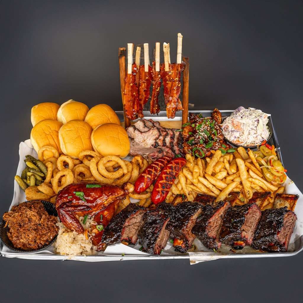 Sharing platter of beef ribs, sliders, onion rings and fries