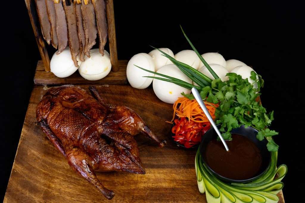 Whole smoked duck with steamed buns, herbs and dipping sauce