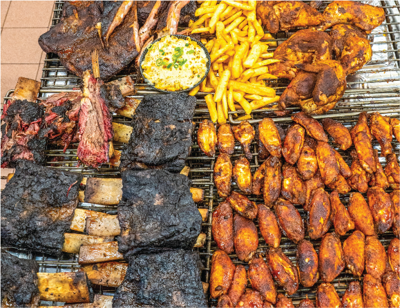 Smoked beef ribs and wings on the grill for All You Can Eat Tuesdays