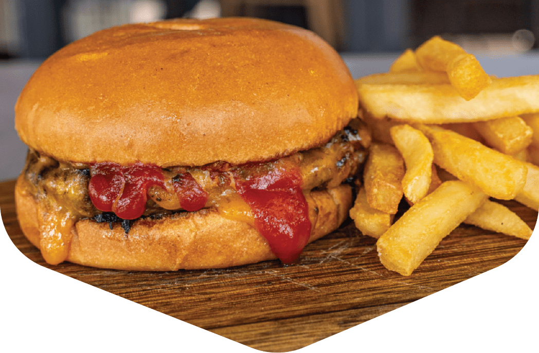 Kids burger with tomato relish and a side of fries on a board