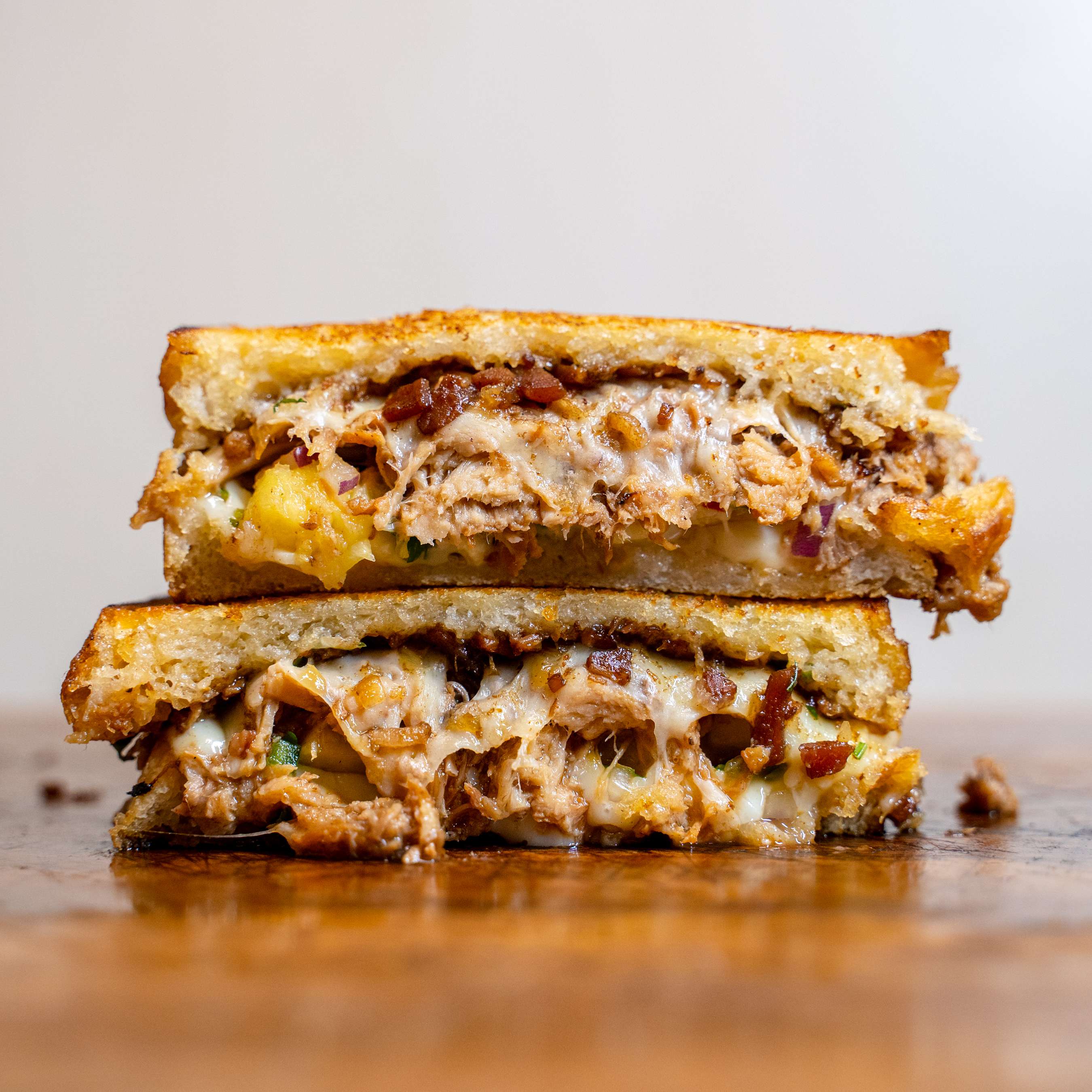 Toastie halves with pulled meat, melted cheese and pineapple