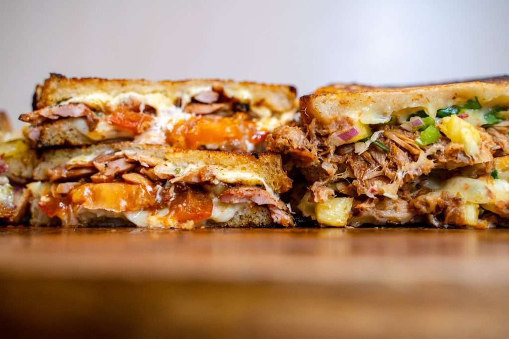 Toastie halves with pulled meat, melted cheese and pickled onion