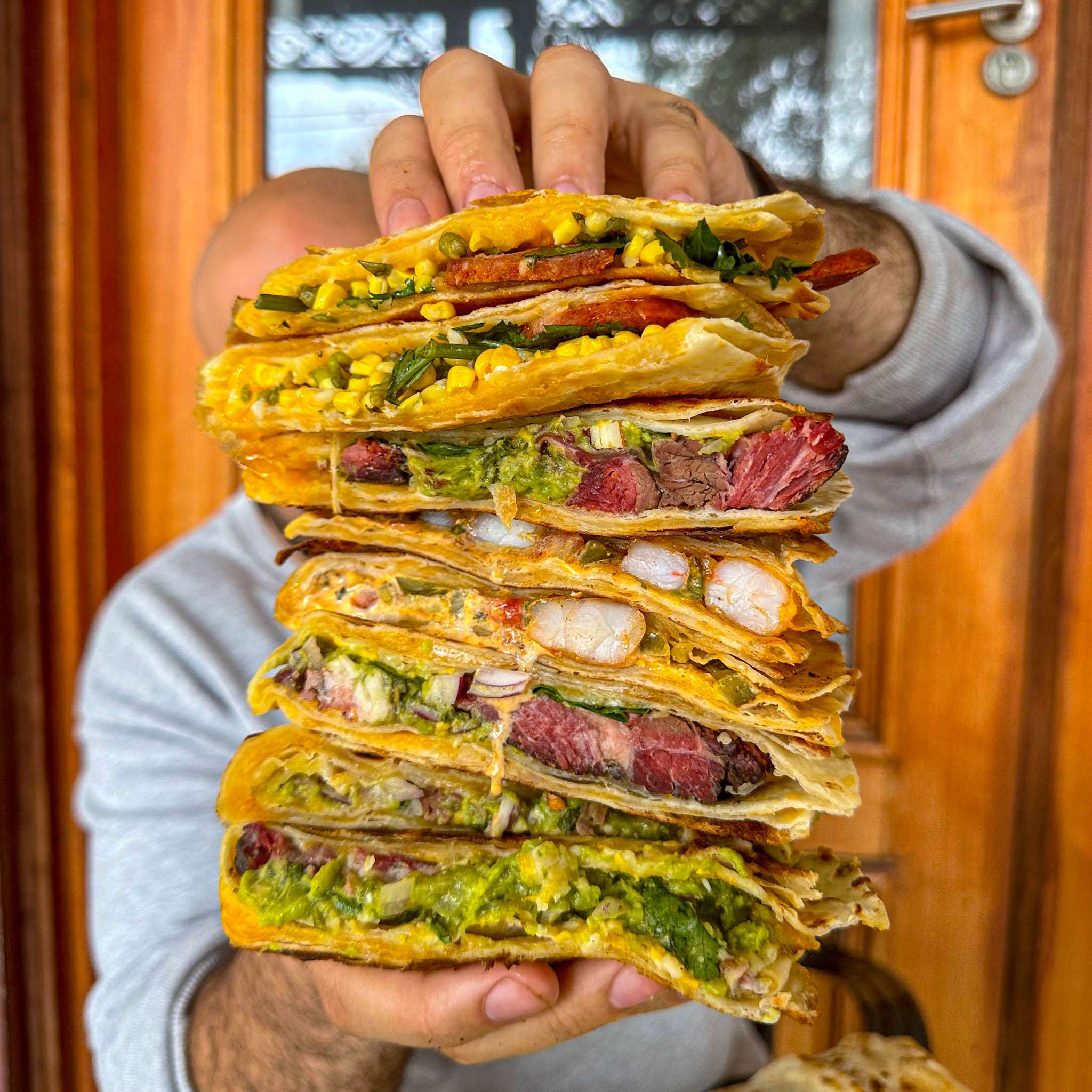 Stack of steak quesadillas filled with corn and guacamole