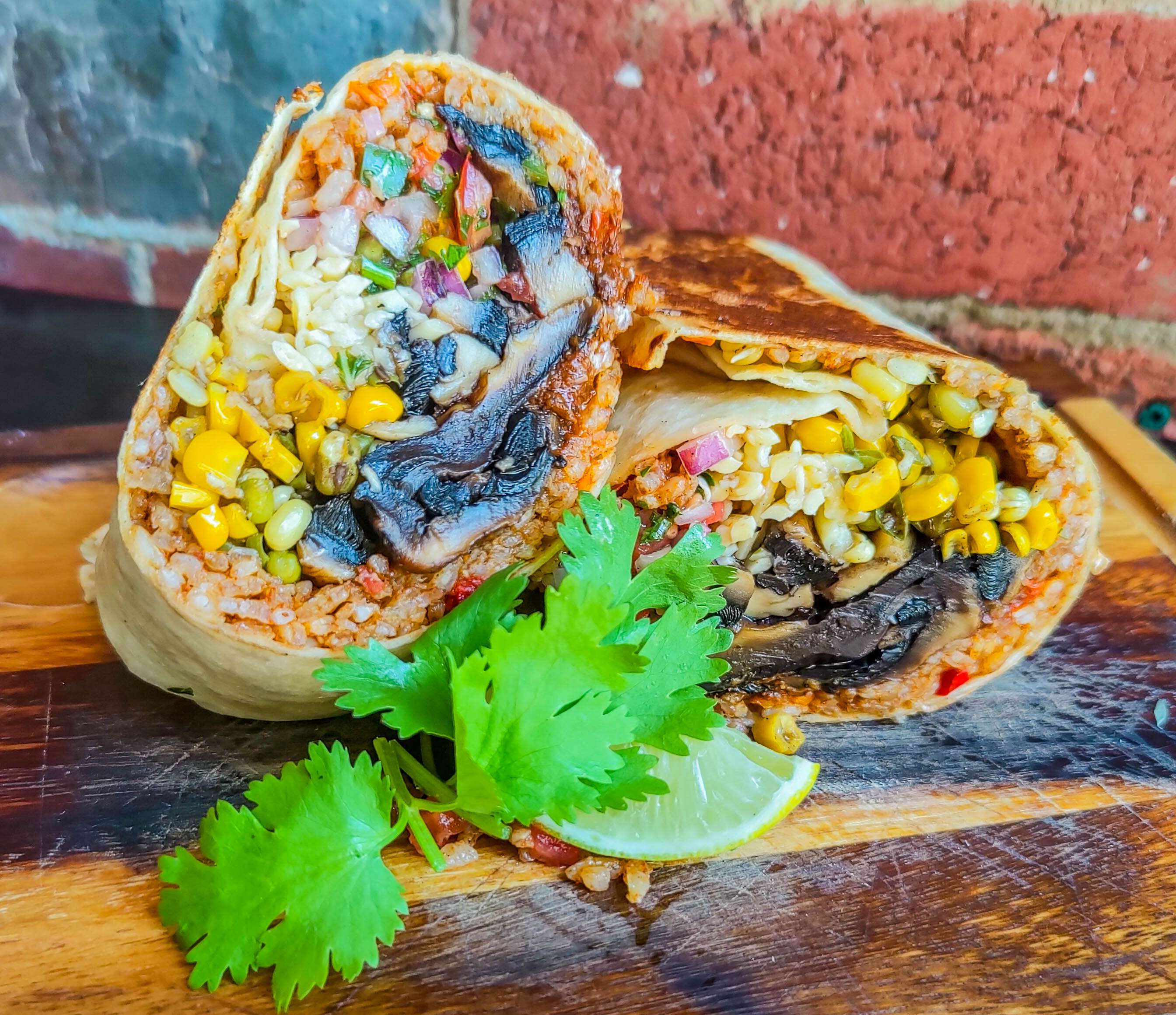 Vegetarian burrito halves with rice, corn and black beans