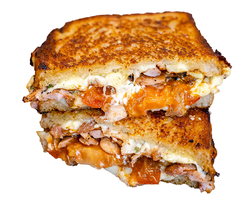 Smoked chicken toastie halves stacked, oozing melted cheese