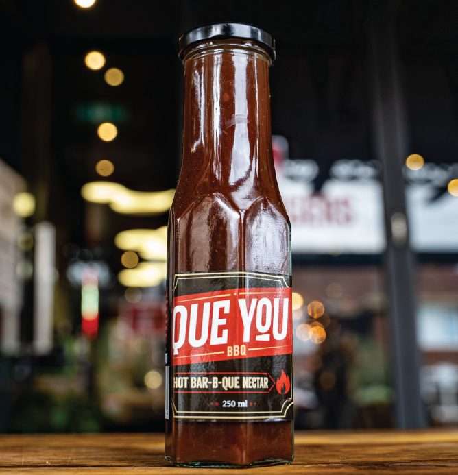 Que You Hot Bar-B-Que Nectar sauce bottle on a timber counter