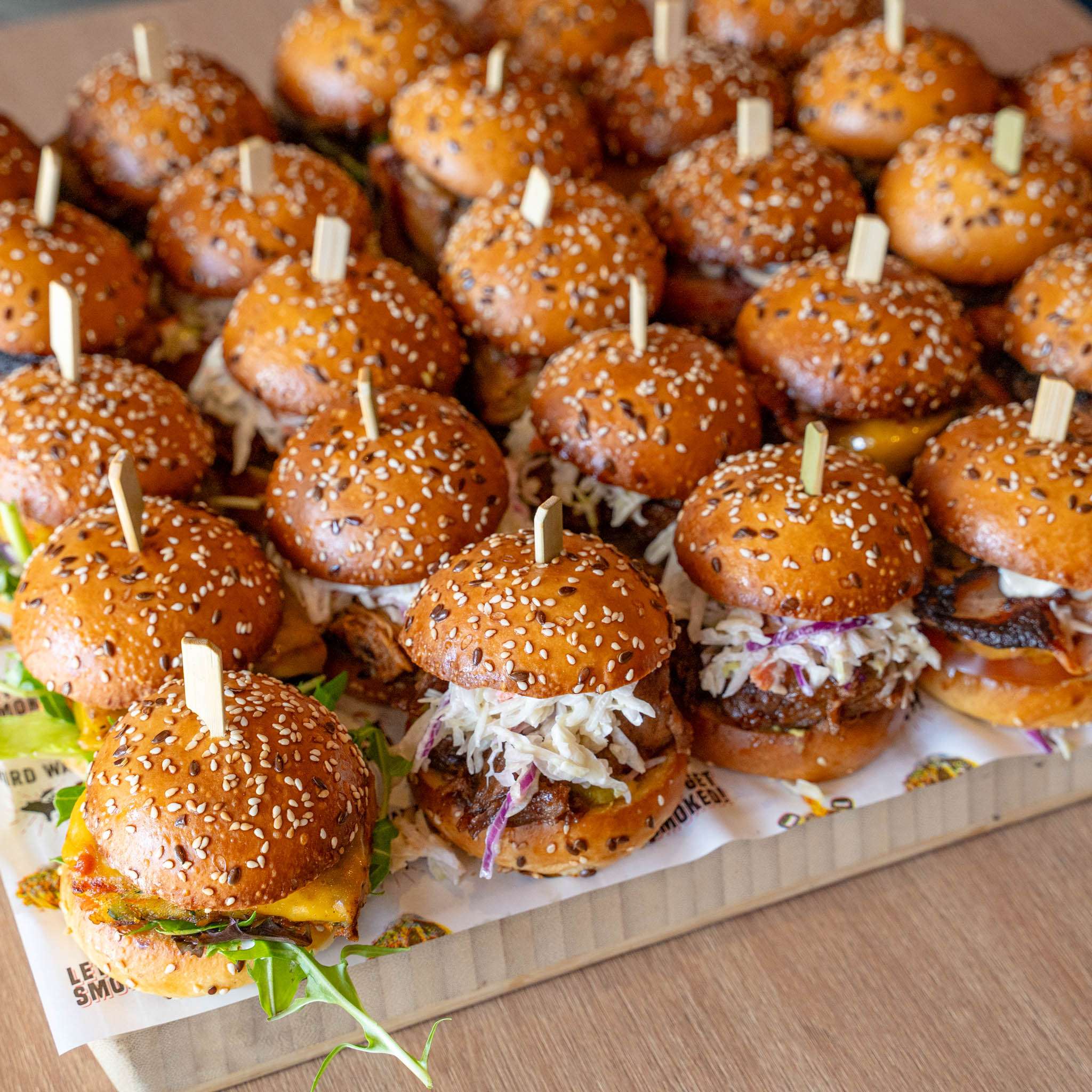 Platter of assorted mini sliders with coleslaw for a catering package