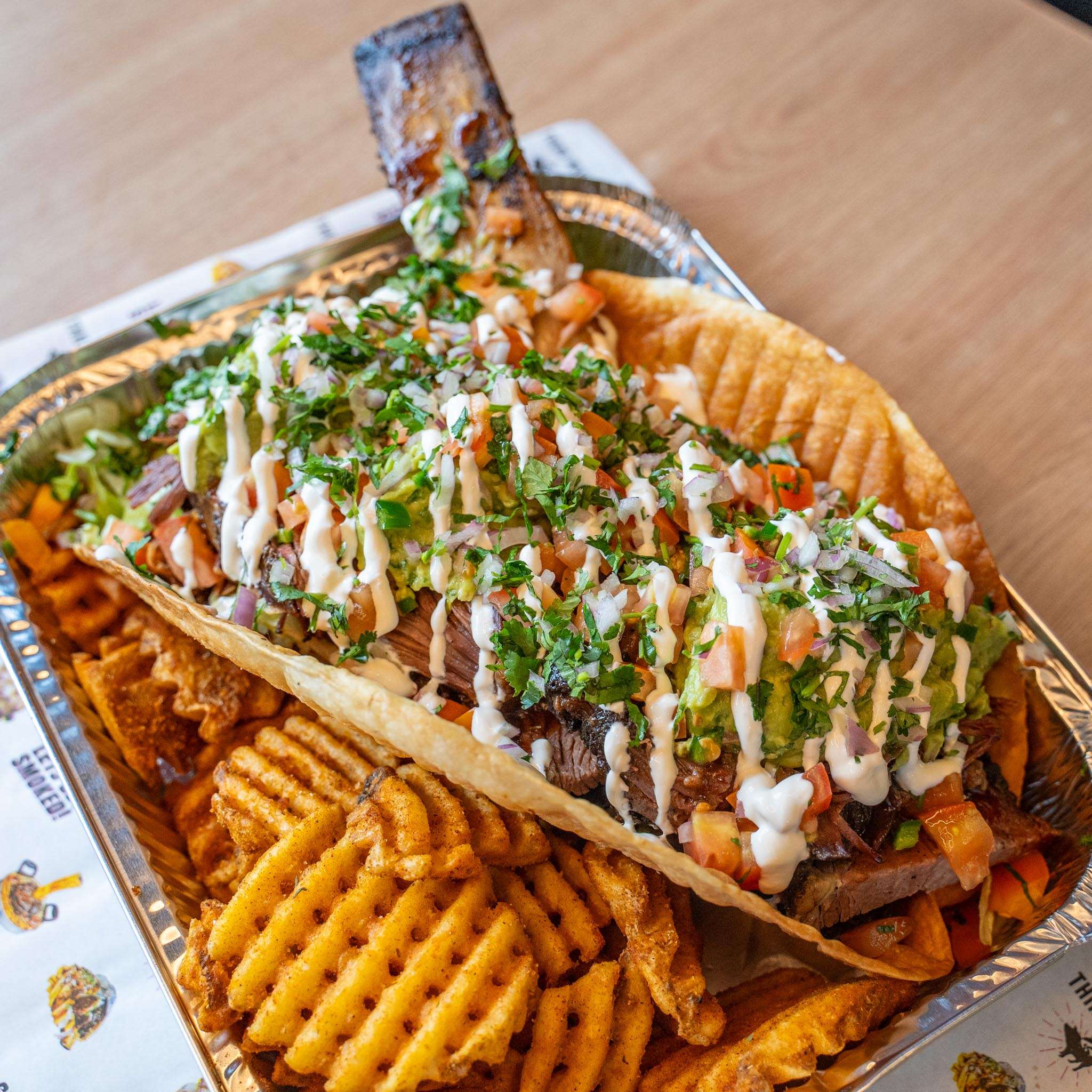 Big Beefy Taco with fresh herbs over a bed of waffle fries