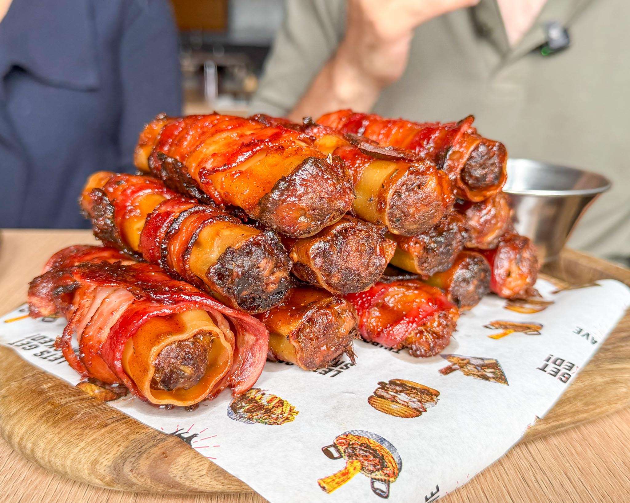 Bacon-wrapped BBQ shotgun shells on a board