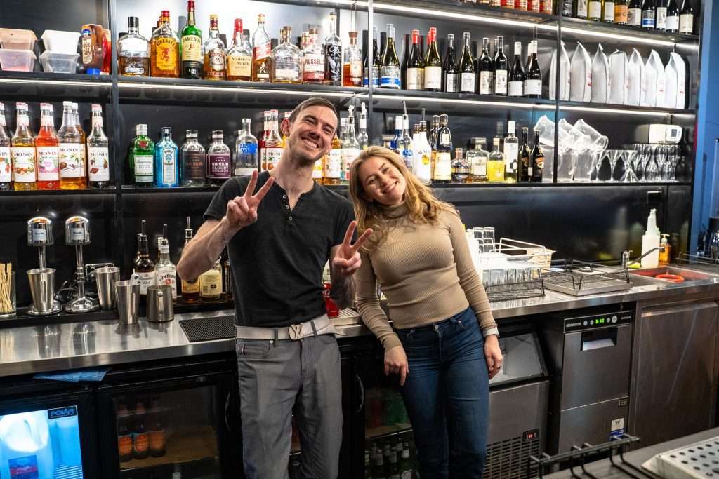 Two staff members posing behind the bar at Third Wave BBQ