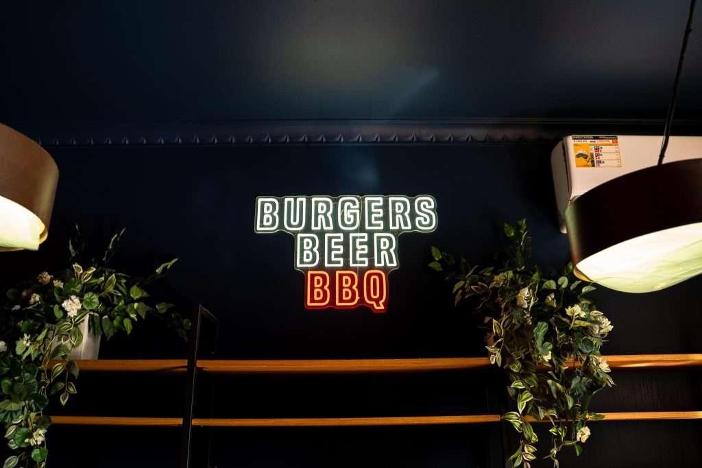 Neon sign reading 'Burgers Beer BBQ' at Third Wave BBQ