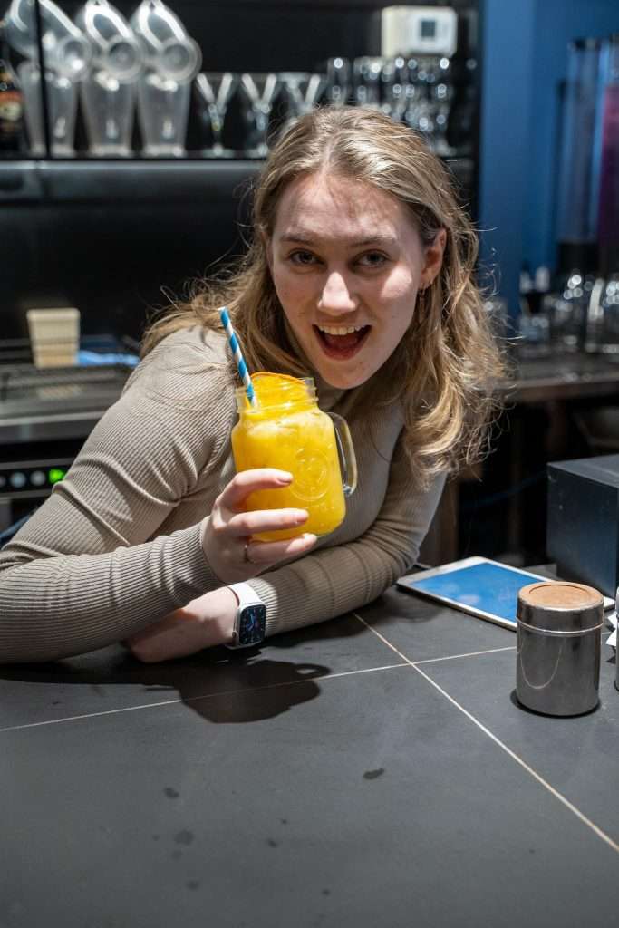 Guest sipping a mango cocktail at the bar, Third Wave BBQ Albert Park
