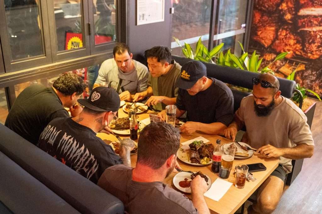 Guests dining together at a table at Third Wave BBQ Applecross