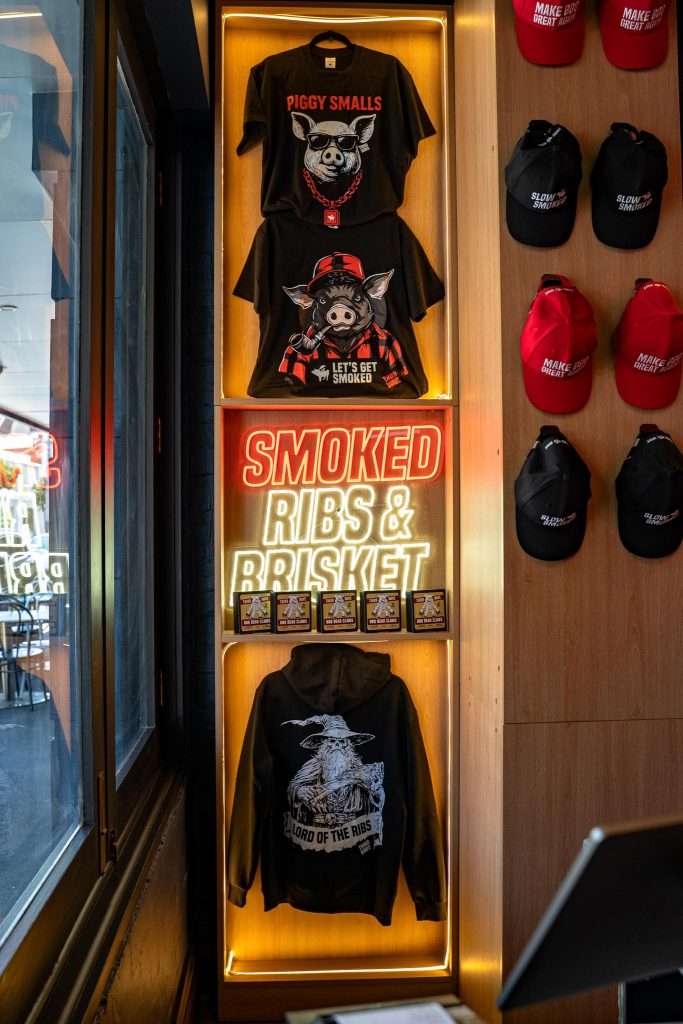 Merchandise display of t-shirts, caps and a hoodie at Third Wave BBQ Ascot Vale