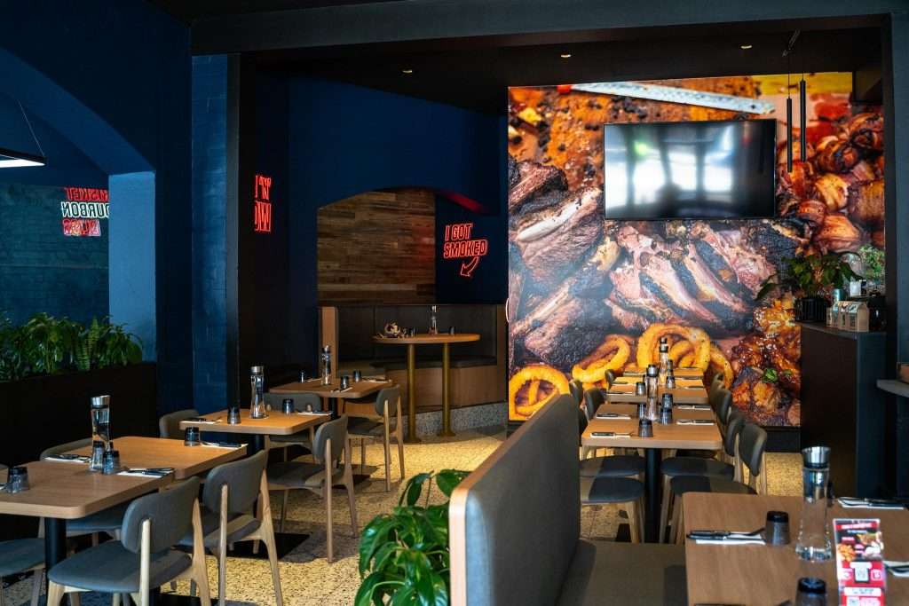 Dining area with a meat-themed wall mural at Third Wave BBQ Ascot Vale