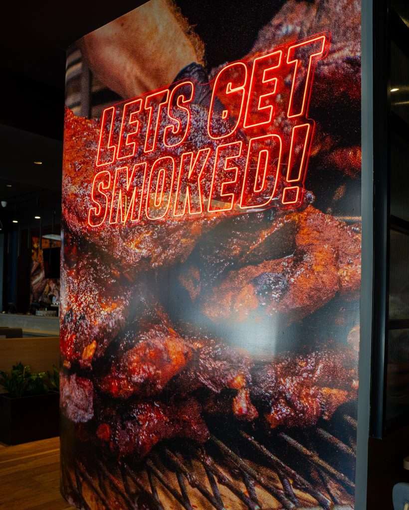 'Let's get smoked' poster with ribs on the grill