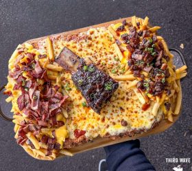 Holy Fluck Parma loaded fries with melted cheese, brisket and a rib bone