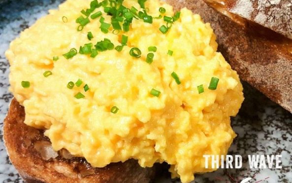 Creamy scrambled eggs piled on toasted sourdough with chives