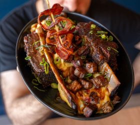 BBQ Banana Split dish with bone-in ribs, held on a plate