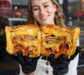 Guest holding two halves of the BBQ Brick showing pulled meat and cheese