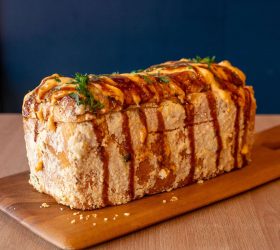 BBQ Brick loaf with sauce drizzle on a wooden board