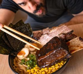 Person eating BBQ ramen with brisket, nori and corn