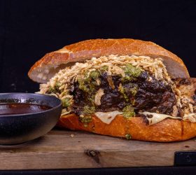 Crusty roll filled with shredded beef, melted cheese and herb sauce