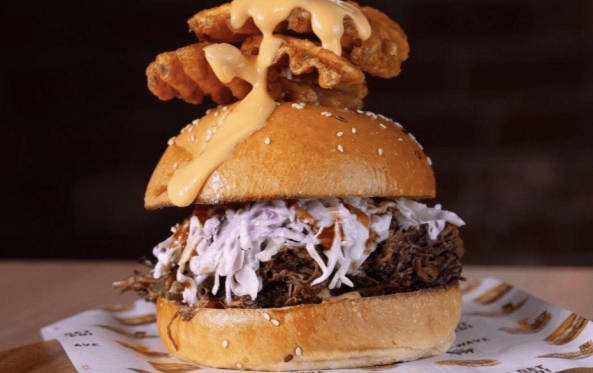 Birria burger with coleslaw and a waffle fry skewer