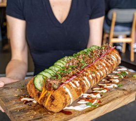 Guest holding the Mega Sumo Sushiritto sliced open showing rice filling