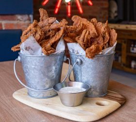 Buckets of chicken fried bacon with a side of dipping sauce