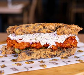Close-up of the Chicken Fried Brisket Fried Chicken Sandwich with pickle and slaw