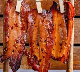 Candy bacon strips hanging from wooden pegs