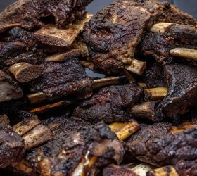 Stack of smoked beef ribs piled on a board