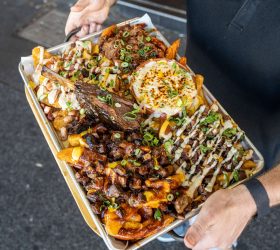 Colossal Loaded Fries tray with cheese sauce, bacon and spring onion