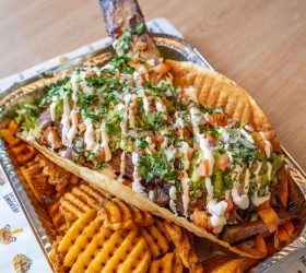 Big Beefy Taco with fresh herbs over a bed of waffle fries