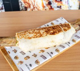 Long Horn Burrito sliced in half on a wooden board